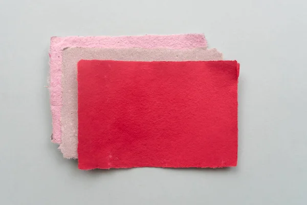 Red sheets of handmade paper on a light background. Paper recycling concept.