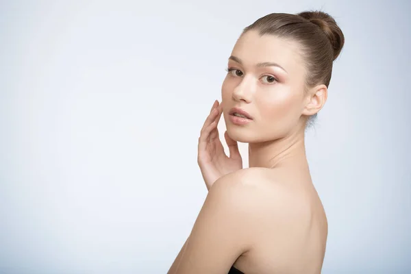 temiz tenli kadın eliyle yanağını dokunur.