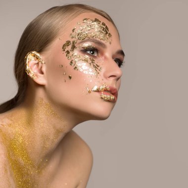 Bir kadının derisinde altın maske. Bir sürü altın parçacıkları. 
