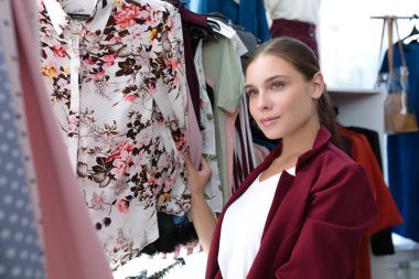 bir mağazada kadın giysi seçer. kadın alışveriş