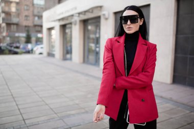 Şehirde kırmızı paltolu moda kadını var. İş adamı. Polis.