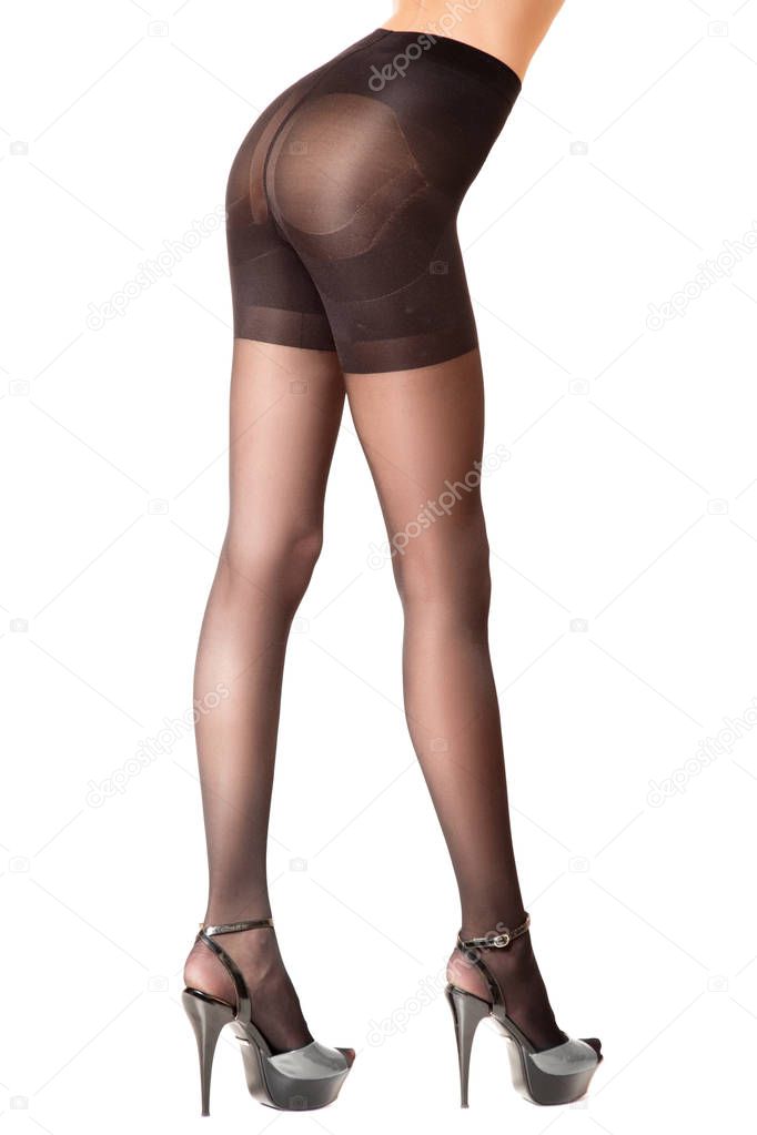 Slender female legs in black katron pantyhose. Side view