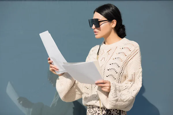 Gözlüklü moda esmeri belgelere bakıyor. Şık bir klon.