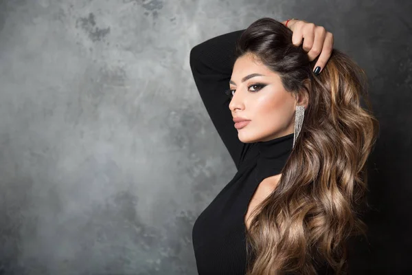 Uzun dalgalı saçlı güzel bir esmer. Gri bir portre