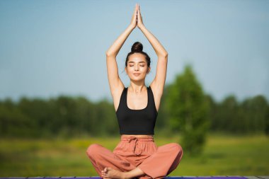 Parktaki güzel genç kadın yoga yapıyor. kopyalama alanı