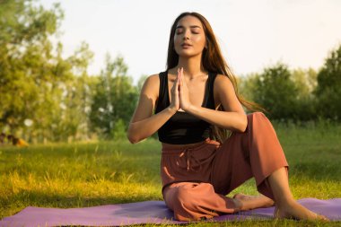 Parktaki yoga kadını. Gün batımı ışığı. Kopyalama alanı