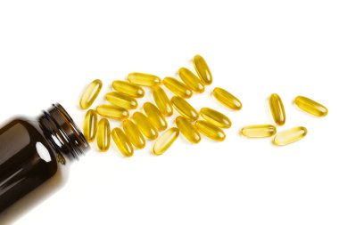 Omega-3 balık yağı kapsülleri şişeden dökülüyor. Vitaminler ve besin takviyeleri