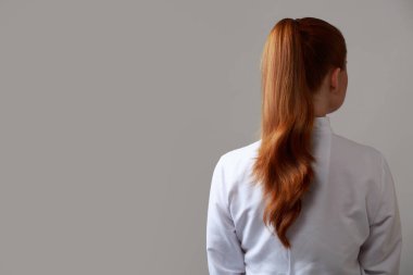 Kırmızı kuyruklu kadın. Arkadan bak. Gri arka plan. Kopyala