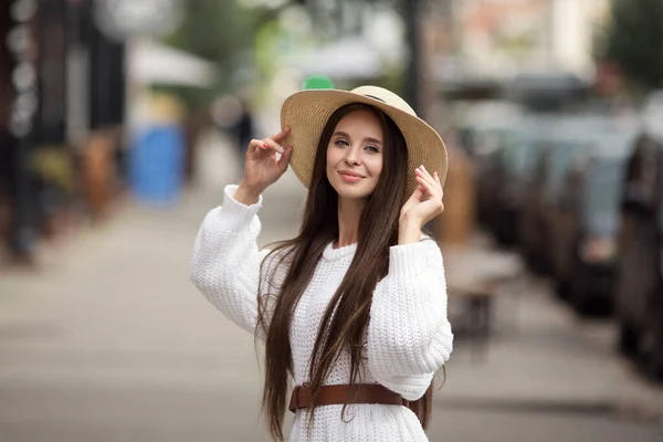 Stylish young woman in a skirt and hat enjoys walking around the city. Hipster