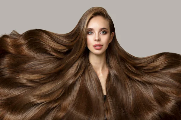Parlak, güzel, esmer, uzun kıvırcık saçlı bir kadın. Gri bir arkaplanda