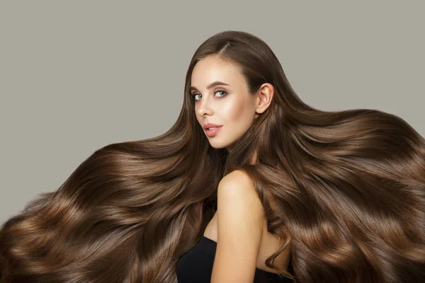 Parlak dalgalı saçlı esmer kadın.