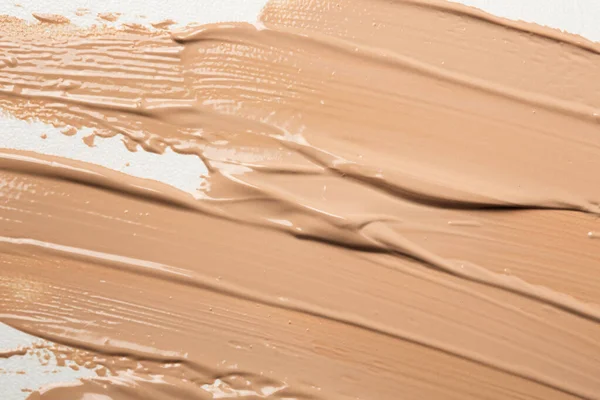 Shades of foundation on a white background. Close-up of various tones of liquid foundation, texture of a makeup product. High quality