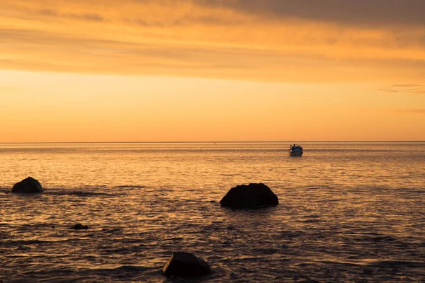 Hallet Koyu'nda gün batımı, Güney Avustralya'da bir tekne ve kayalarla