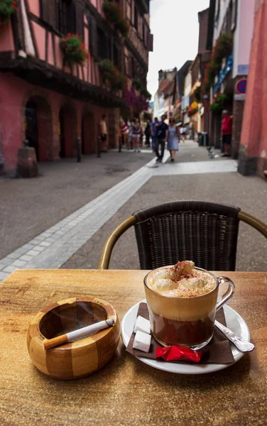 Coffee, cigarette and ashtray on a table at a french tourist spot