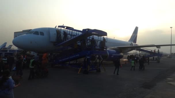 Delhi, India - 4 april 2020 Passagiers instappen indigo vliegtuig op delhi luchthaven tijdens zonsondergang — Stockvideo