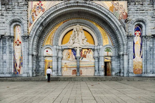 Vooringang van de Basiliek van de Rozenkrans in Lourdes met pelgrims Stockfoto
