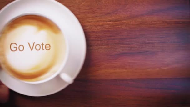 Hand placera kopp kaffe med latte konst på ett träbord — Stockvideo