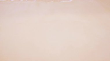 Okyanus dalgası, keşke burada olsaydınız demek için geri çekiliyor. Seyahat reklamları, tatil videoları ya da romantik mesajlar için mükemmel bir şekilde kumlara yazılmış..