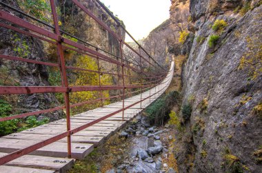 Yürüyüş parkuru Los Cahorros de Monachil (Granada) sonbaharda. Monachil Nehri'nin yanında oyulmuş etkileyici bir geçit. Bu şelaleler, mağaralar ve asma köprüler ile tekil güzellik bir yerdir.
