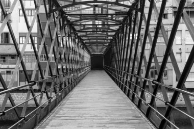 Girona'da alacakaranlıkta Onyar Nehri üzerindeki Eyfel Köprüsü, Katalonya (İspanya)