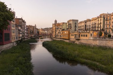 Su nehir Onyar, Girona, Catalonia, İspanya yansıyan renkli sarı ve turuncu evleri.
