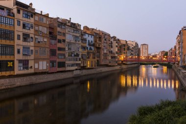Su nehir Onyar, Girona, Catalonia, İspanya yansıyan renkli sarı ve turuncu evleri.