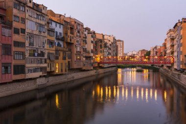 Su nehir Onyar, Girona, Catalonia, İspanya yansıyan renkli sarı ve turuncu evleri.