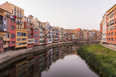 Su nehir Onyar, Girona, Catalonia, İspanya yansıyan renkli sarı ve turuncu evleri.