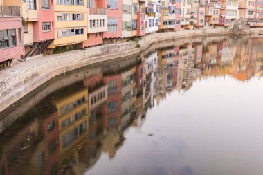Su nehir Onyar, Girona, Catalonia, İspanya yansıyan renkli sarı ve turuncu evleri.