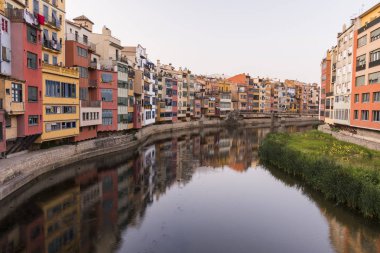 Su nehir Onyar, Girona, Catalonia, İspanya yansıyan renkli sarı ve turuncu evleri.