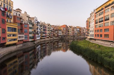 Su nehir Onyar, Girona, Catalonia, İspanya yansıyan renkli sarı ve turuncu evleri.
