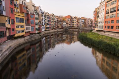 Su nehir Onyar, Girona, Catalonia, İspanya yansıyan renkli sarı ve turuncu evleri.