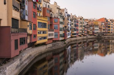Su nehir Onyar, Girona, Catalonia, İspanya yansıyan renkli sarı ve turuncu evleri.