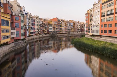 Su nehir Onyar, Girona, Catalonia, İspanya yansıyan renkli sarı ve turuncu evleri.