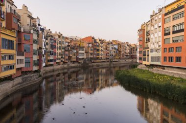 Su nehir Onyar, Girona, Catalonia, İspanya yansıyan renkli sarı ve turuncu evleri.