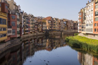 Su nehir Onyar, Girona, Catalonia, İspanya yansıyan renkli sarı ve turuncu evleri.