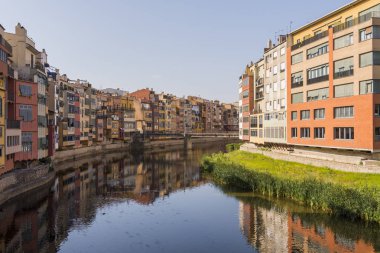 Su nehir Onyar, Girona, Catalonia, İspanya yansıyan renkli sarı ve turuncu evleri.
