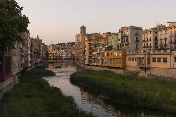 Colorful yellow and orange houses reflected in water river Onyar, in Girona, Catalonia, Spain.