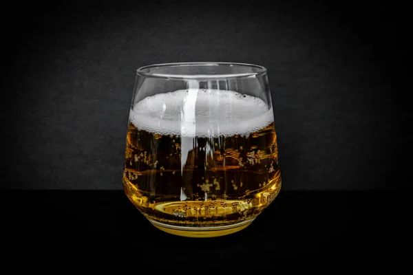 Glass of delicious beer. Light alcohol drink. Dark background.