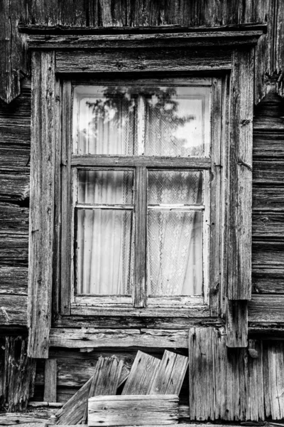 Uma janela em uma velha casa de madeira esquecida. — Fotografia de Stock