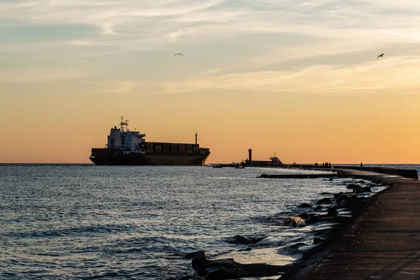 Envío global y negocios mundiales. Embarcación de contenedores pasa a través del faro para ir al mar abierto. — Foto de Stock