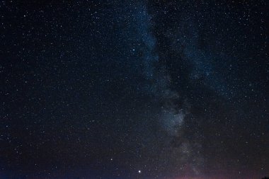 Açık gece gökyüzü Samanyolu ve büyük miktarda yıldızla.