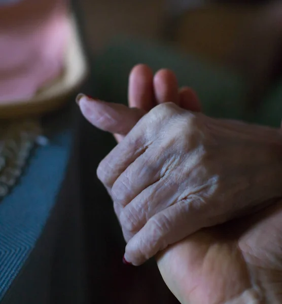Helping hands, care for the elderly concept. Care giver holding hand of elderly woman patient. Senior woman  in family relationship concept. Grandmother with son, daughter, doctor, or caregiver.