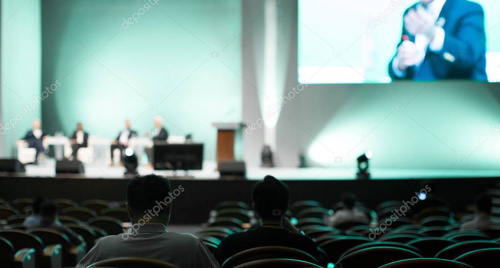 Conference photo audience and speakers giving speech. Seminar presenters on a panel during forum. Corporate managers in sales executive training discussion on stage. Investor pitch presentation.