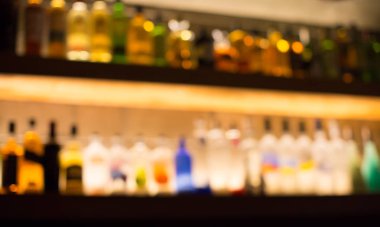 Geceleri restoranda, pub'da veya barda sahne. Ürün görüntülemek için restoran, bar veya kafeterya arka planda deodaklı arka plan ve şişeler. Gece kulübü partisi veya içecekler için bulanık bar arka plan. 