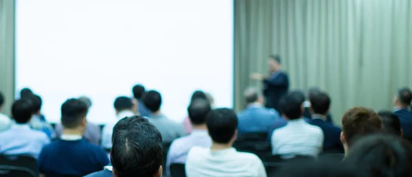 Conference photo audience and tech speaker giving speech. Seminar presenter at CEO forum. Corporate manager in executive training discussion on stage. Investor pitch presentation workshop picture.