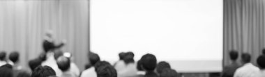 Kurumsal konferansta konuşmacı tarafından yapılan konuşmayla arka planda bulanıklık. Yönetici, girişimciler için liderlik atölyesinde izleyicilere sunum yapıyor. Tanışan insanların fotoğrafı..