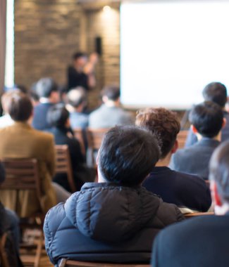 Buluşma konsepti. İş adamlarının eğitim ve öğrenmesiyle konferans bulanıklaşıyor. Bulanık geçmişi olan koçluk konsepti. Seminer sırasında salonda dinleyicilerle konuşan konuşmacı. Ders serisi konuşması.