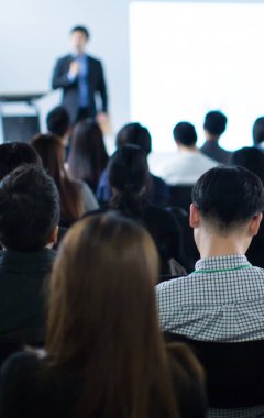 Şirket konferansında konuşma yaparken sunucu. Seminer fotoğrafında iş dünyasının izleyicilerine konuşma yapan konuşmacı. Şirket eğitim etkinliği sırasında salonda tartışmayı yürüten yönetici yönetici.. 