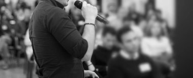 Şirket konferansında konuşma yaparken sunucu. Seminer fotoğrafında iş dünyasının izleyicilerine konuşma yapan konuşmacı. Şirket eğitim etkinliği sırasında salonda tartışmayı yürüten yönetici yönetici.. 